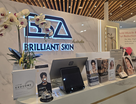 Reception desk with Brilliant Skin Australia logo and floral décor